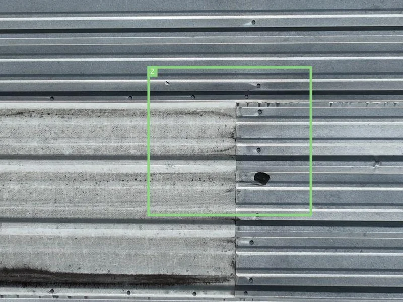 Close-up aerial photo of the CrossFit eXalted roof showing surface rust and gasket wear on a roof vent penetration