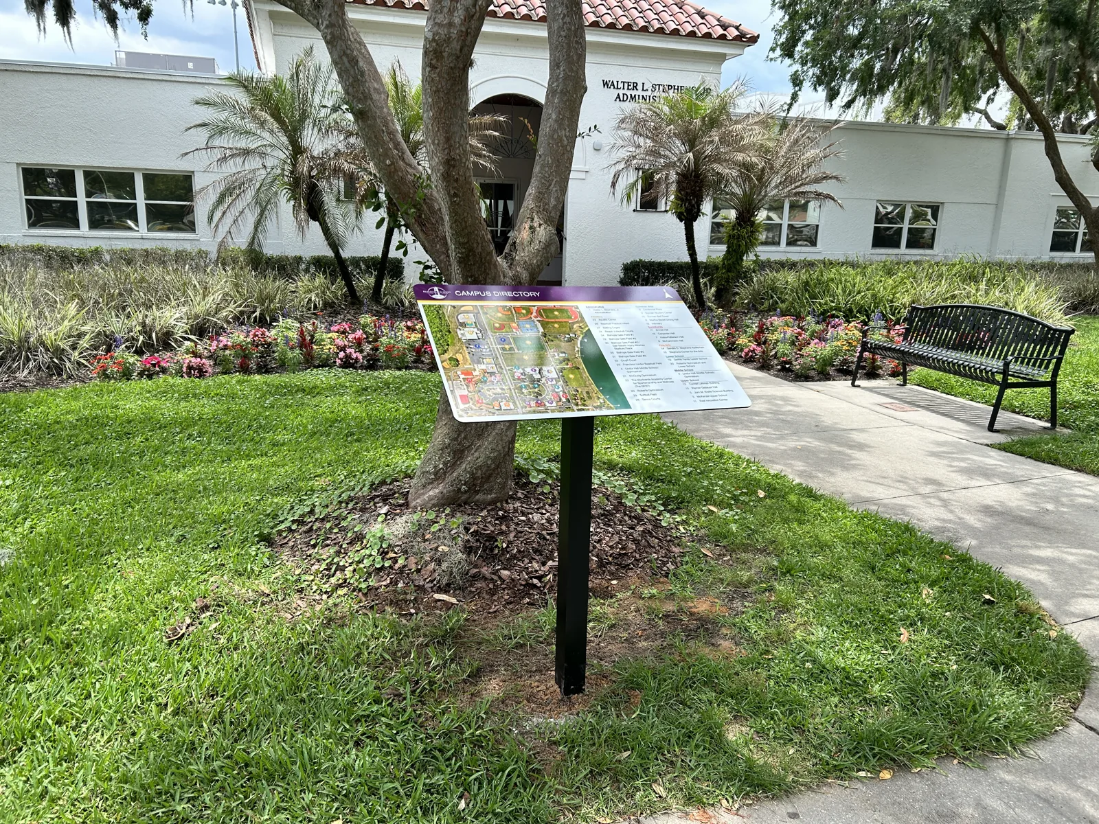 Campus directory sign at Montverde Academy installed in front of the Walter L. Stephens, Jr. Administration building, showing the section crop with the building's distinctive Spanish Mediterranean architecture in the background